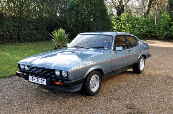 Забравете всички втръснали клишета, Ford Capri 2.8i е готин автомобил. Дългият преден капак, управлението със задно задвижване, алуминиеви джанти и кремав V6 мотор отпред го правят почти перфектната британска "мускулеста" кола.

Capri (Mk3) влезе в продажба през 1978 г. и изглеждаше страхотно с четирите си фара и малкия спойлер на багажника. Въпреки това през 1982 година Ford трябваше да се откаже от стария 3.0-литров V6 поради проблеми с емисиите. И така се роди Capri 2.8i.

Неговите 158 к.с. му дадоха достатъчно блясък в новата вълна от хотхечове. Моторът  звучеше много по-добре. И, разбира се, имаше две изпускателни тръби.  Хората го харесаха и това позволи на Ford да поддържа производствените линии на Capri работещи няколко години по-дълго, отколкото първоначално беше планирано.